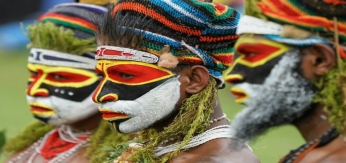Papua New Guinea men in traditional colors and face painting.