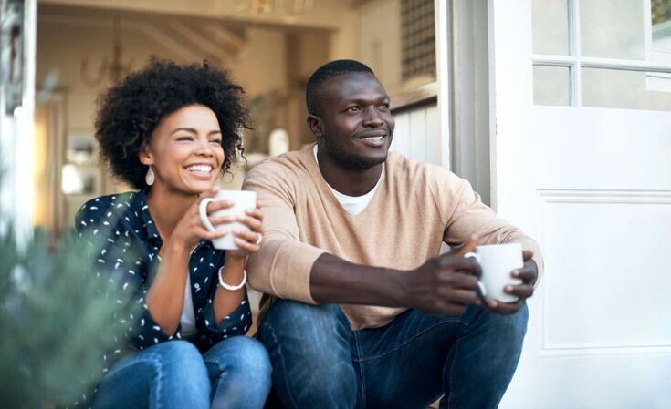 image of a beautiful young couple enjoying coffee time and discussing their real estate business.